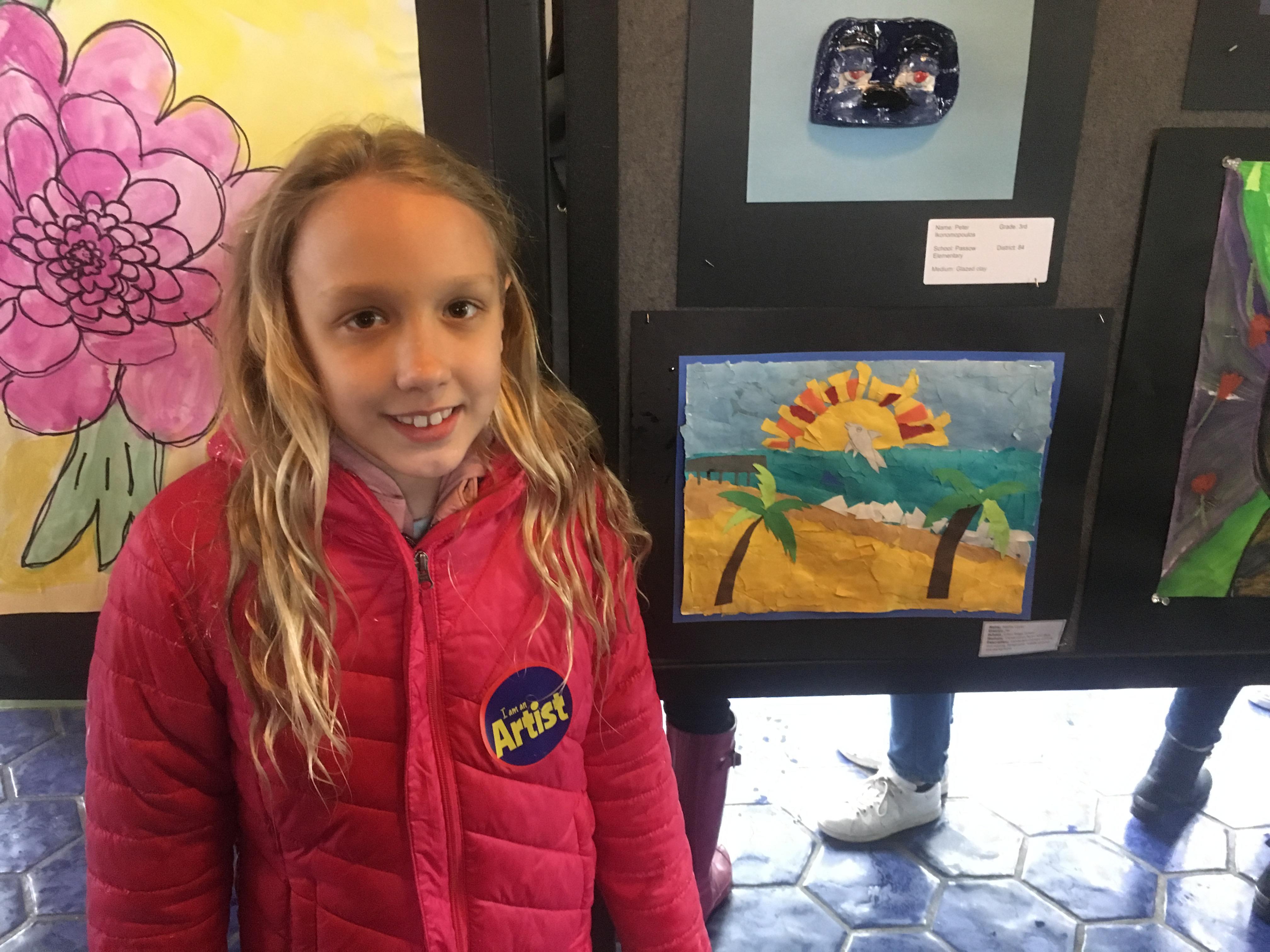 girl posing in front of her artwork