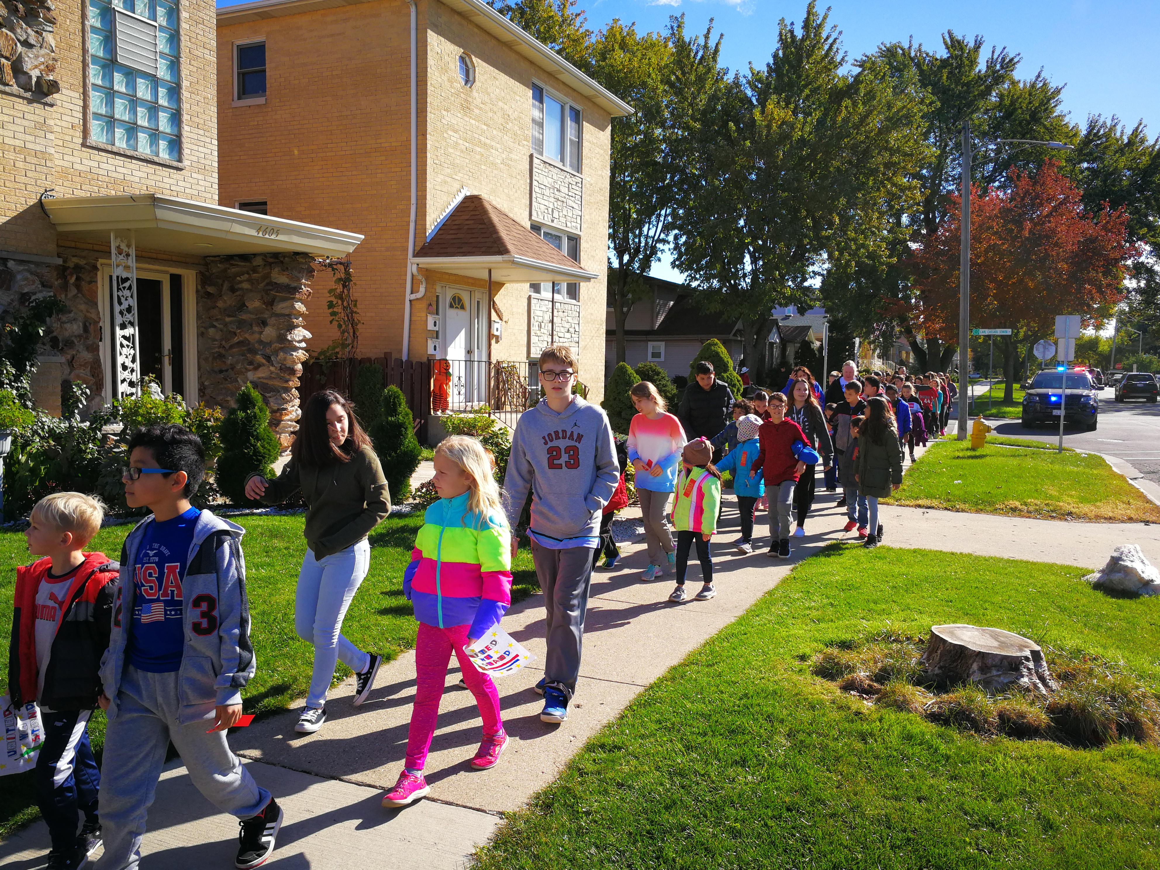 image of red ribbon walk, group students walking around the neighborhood