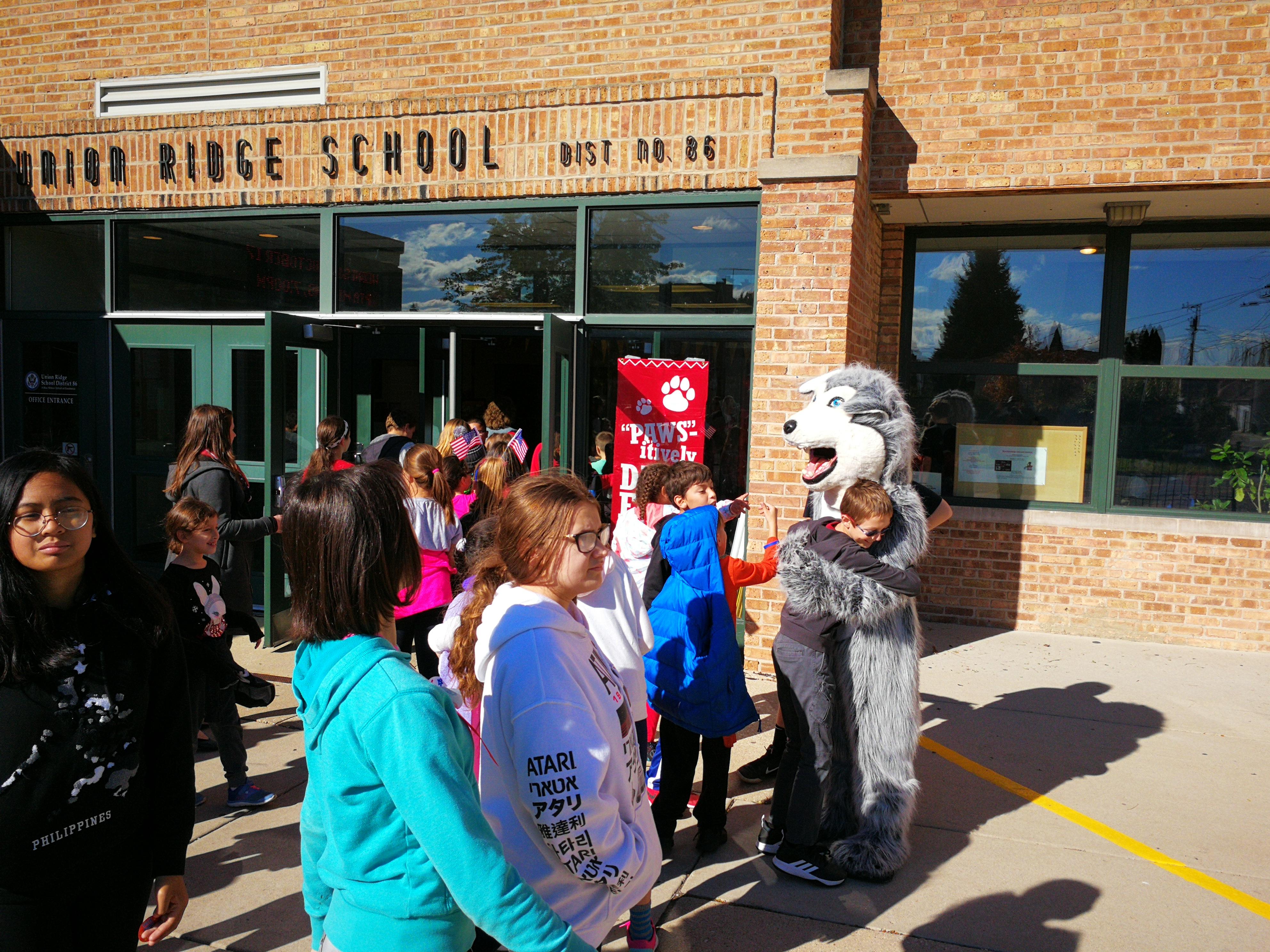 image of red ribbon walk, student hugging the husky mascot 