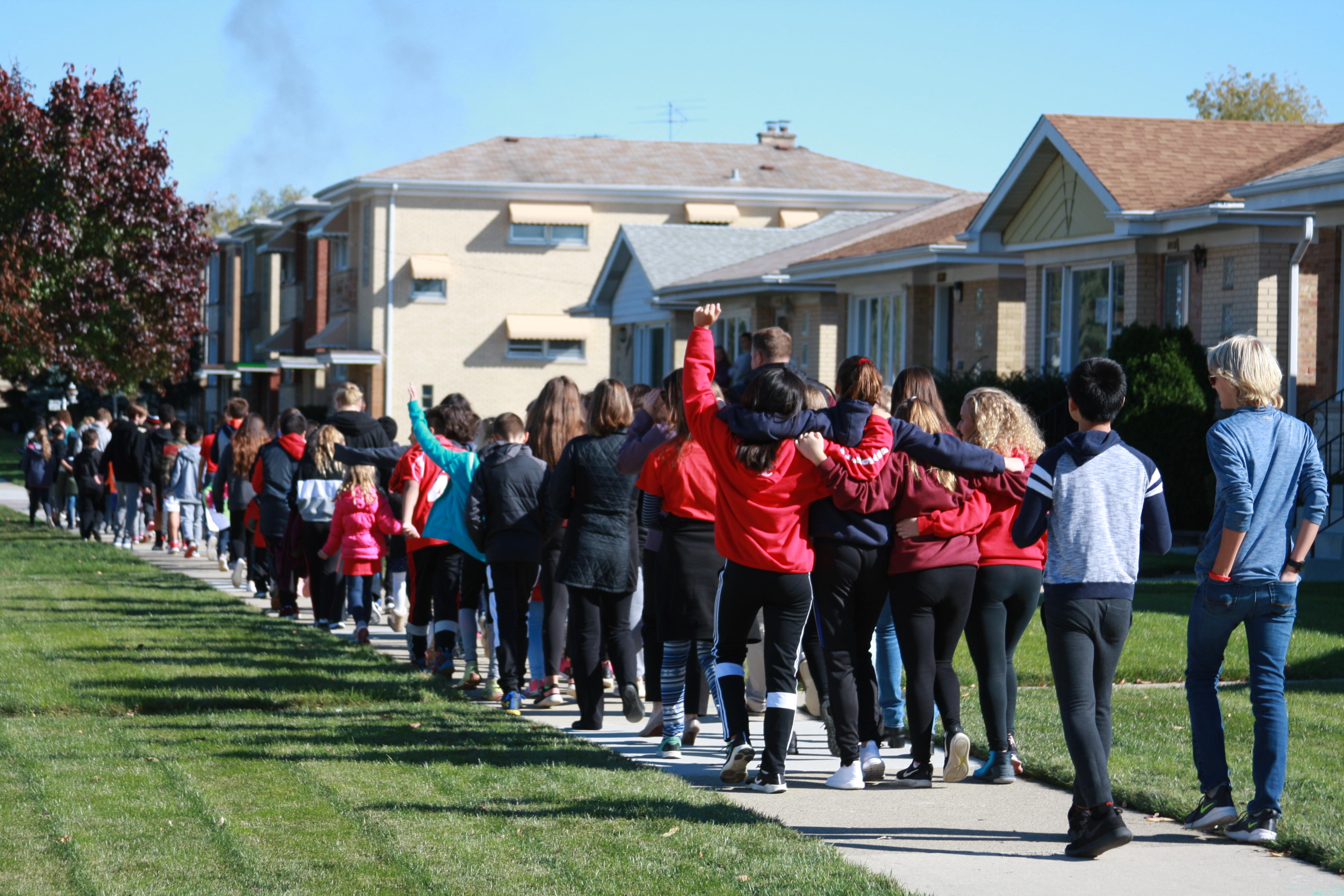 image of red ribbon walk, group of students walking united
