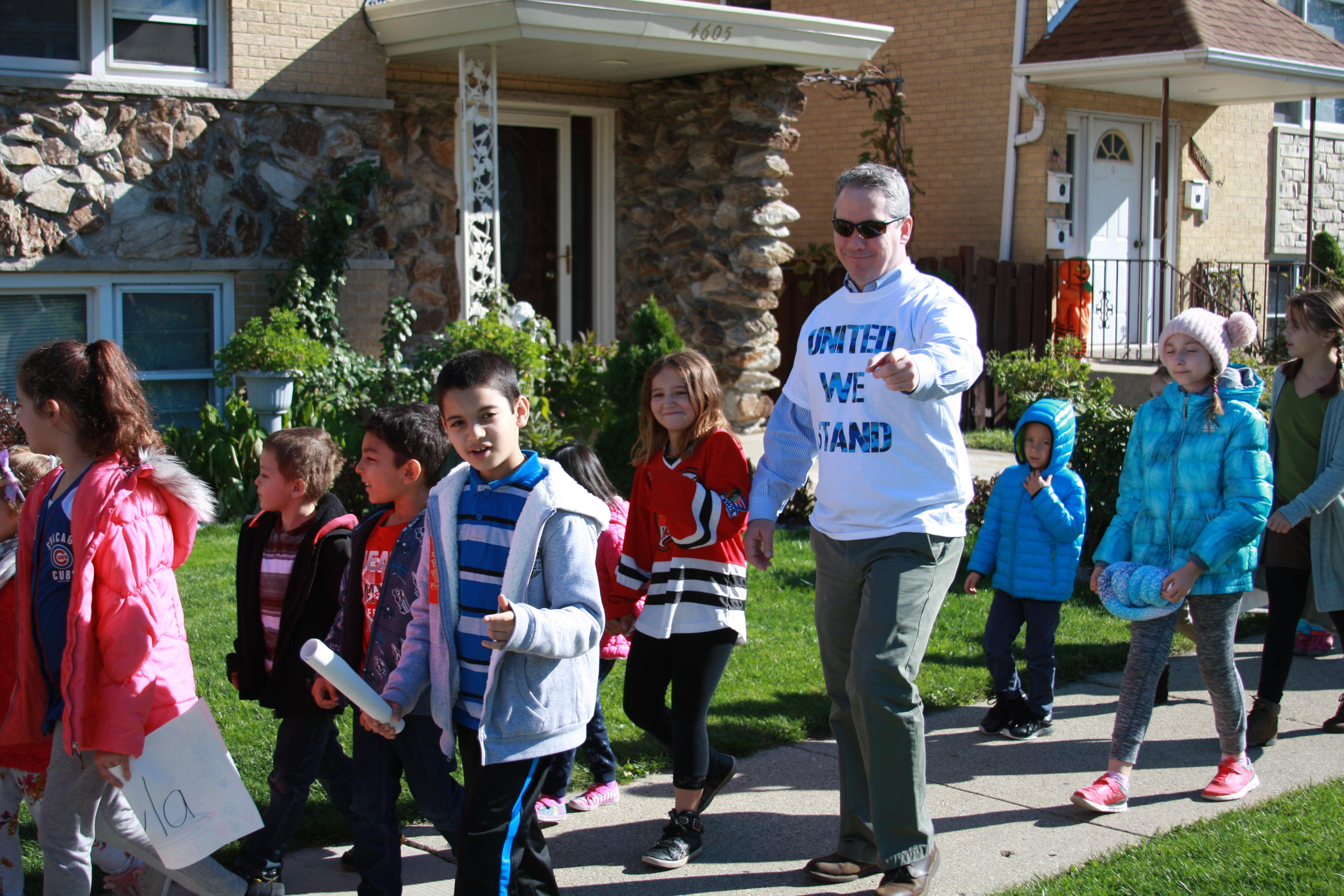 image of red ribbon walk, the school superintendent walking united with students