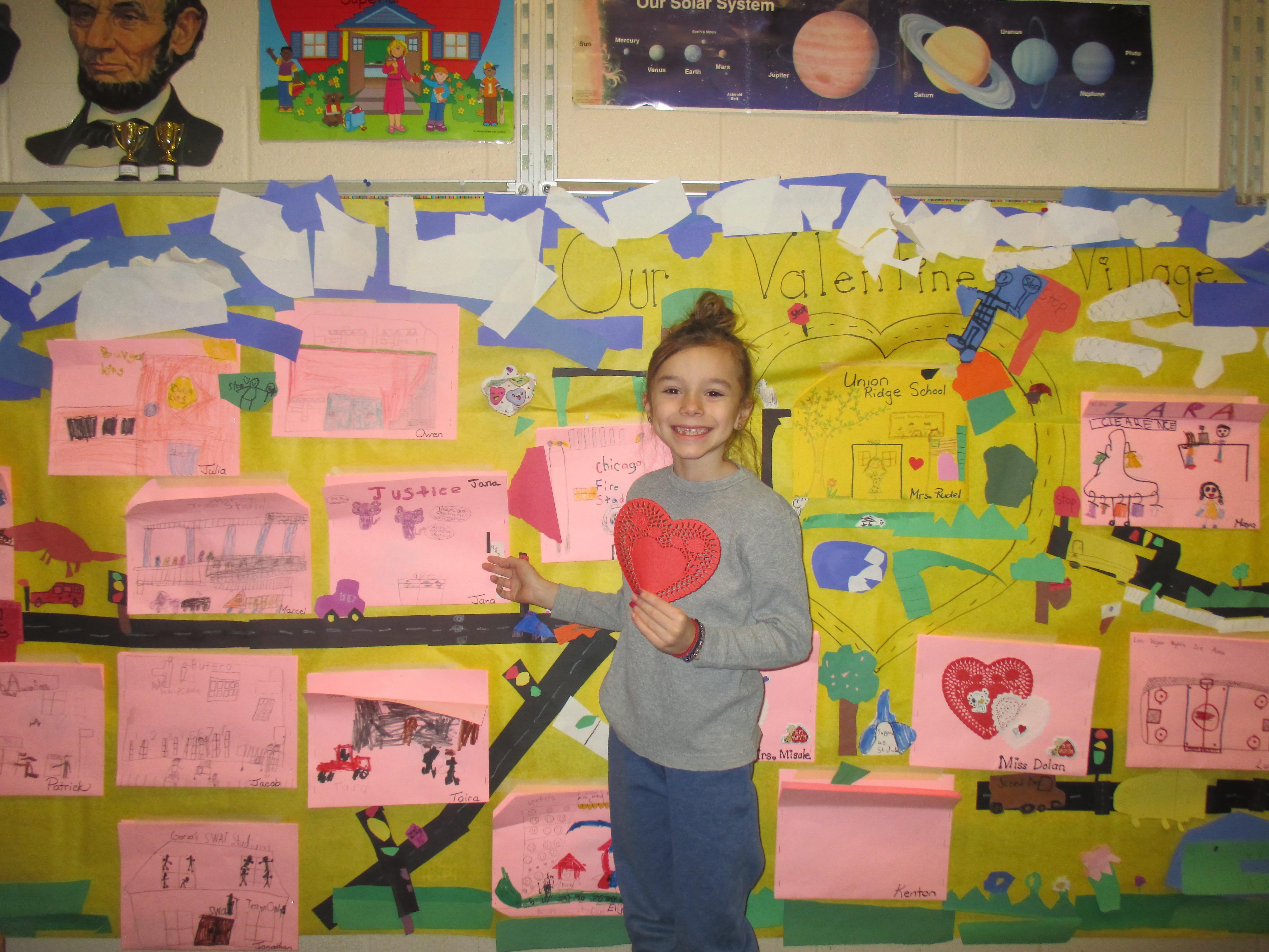 student posing  in front of community map 