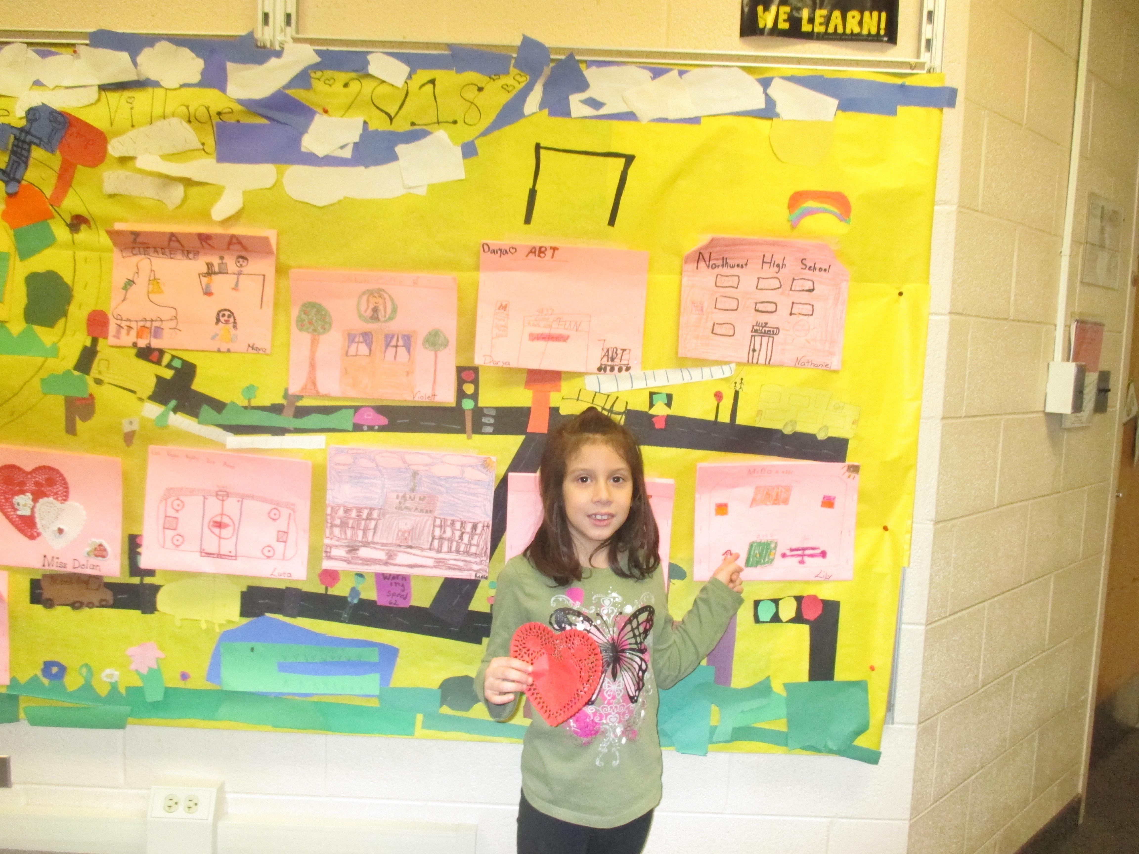 student posing  in front of community map