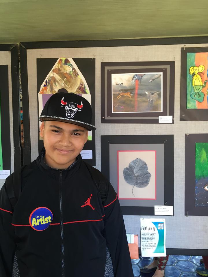 Union Ridge Student, boy Artist, posing with artwork
